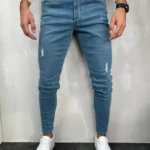 Muške farmerke u teksas plavoj boji sa elastinom i stitnim cepanim detaljima na prednjoj strani.