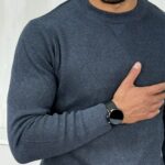 Bliži prikaz muškog teget džempera dugih rukava sa teksturiranim materijalom, fokus na detalje oko ovratnika.