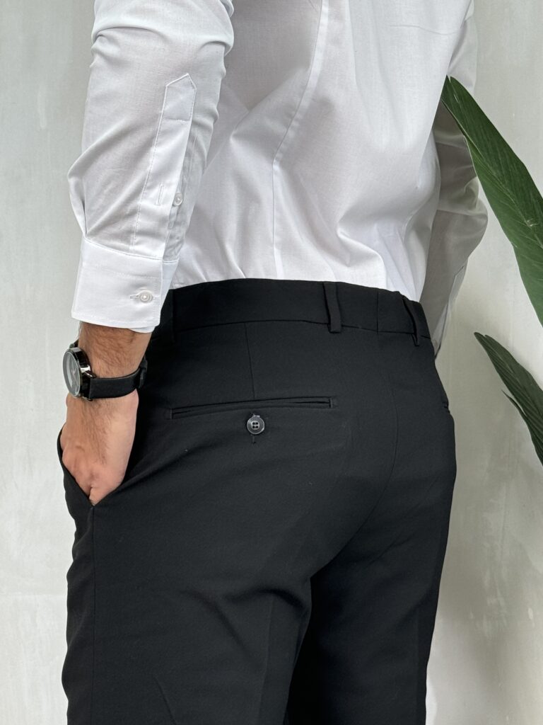 Elegantne muške pantalone u crnoj boji, kroj slim fit. Prikaz gornjeg dela zadnje strane sa akcentom na džepove.