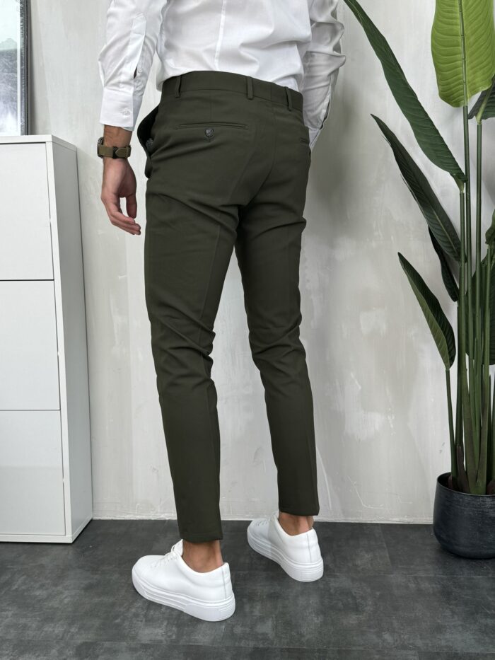 Elegantne muške pantalone maslinasto zelene boje, slim fit kroj sa duplim kopčanjem na prednjoj strani. Prikaz modela sa zadnje strane.