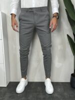 Elegantne muške pantalone u sivoj boji slim fit kroja uparene sa belim patikama i belom košuljom. Prikaz prednje strane.