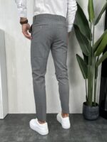 Elegantne muške pantalone u sivoj boji slim fit kroja uparene sa belim patikama i belom košuljom. Prikaz zadnje strane.