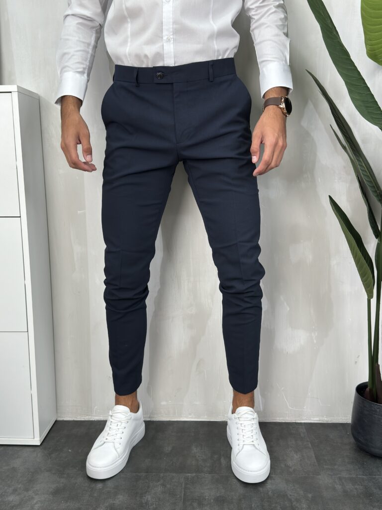 Elegantne muške pantalone sa duplim kopčanjem na prednjoj strani u teget boji, kroj slim fit. Prikaz prednje strane.