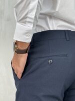 Elegantne muške pantalone u teget boji, kroj slim fit. Prikaz gornjeg dela zadnje strane sa akcentom na džepove.