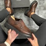 Elegantne muške wingtip cipele u braon boji sa kopčama i visokim đonom, detalj gornjeg dela.