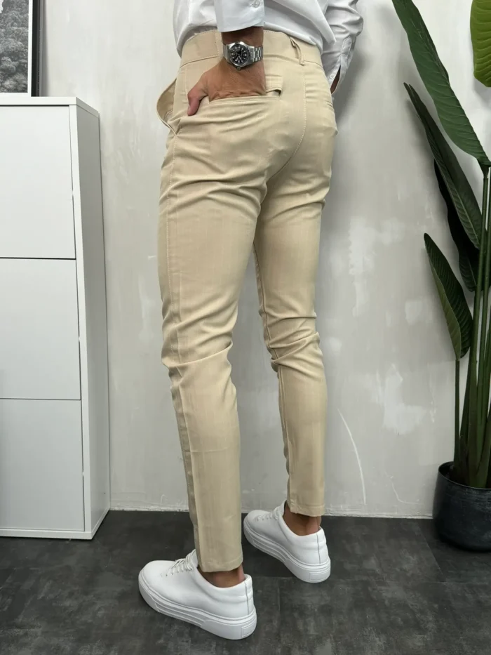 Zadnja strana bež elegantnih pantalona sa belim prugama.