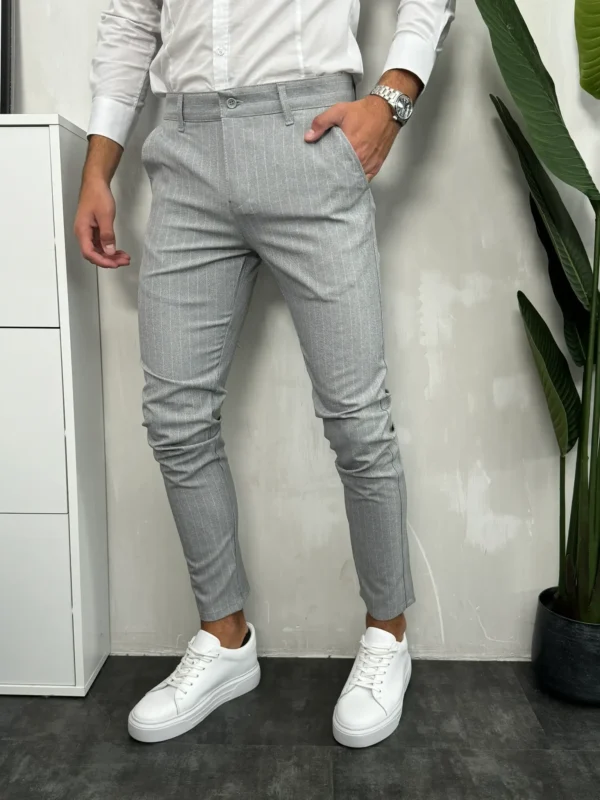 Sive muške pantalone sa belim prugama, slim fit kroj, elegantan i moderan izgled sa belim patikama.