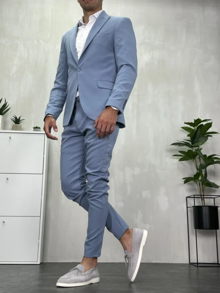 Muško svetloplavo odelo sa modernim slim fit krojem, model u pokretu.