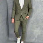 Muško odelo u maslinasto zelenoj boji u kombinciji sa belom košuljom i belim elegantnim patikama, prednji prikaz.