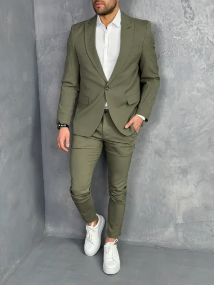 Muško odelo u maslinasto zelenoj boji u kombinciji sa belom košuljom i belim elegantnim patikama, prednji prikaz.