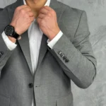 Tamno sivi muški sako sa jednostrukim kopčanjem, detaljan prikaz izbliza sa naglaskom na rukave i dugme na pojasu.